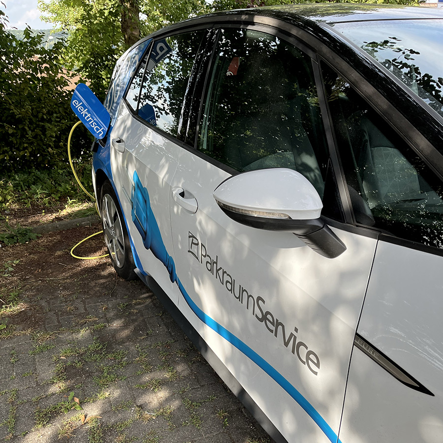 Parkraum Service Auto wird an einer Ladesäule geladen